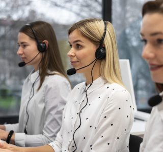 colleagues-working-together-call-center-with-headphones